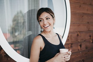 A smiling woman with a cup of coffee