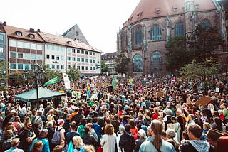 A crowd of people in an open area in a city.