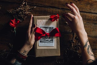 a book wrapped as a gift with a red bow