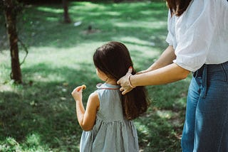 Woman doing her daughter’s hair