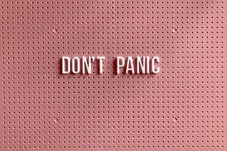 Pink and white Don’t Panic sign