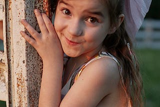A kid smiling in all her brightness.
