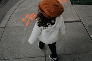 A child walking on a sidewalk