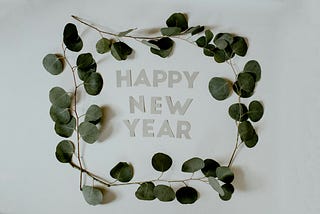 Green foliage encircling the words “happy new year”