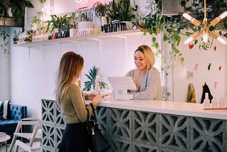 A customer at a counter being served by the employee