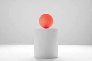 red ball on a white pedestal
