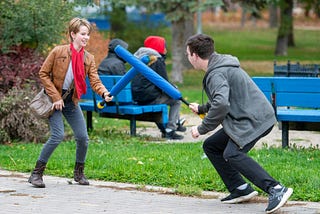 Two people playing with Nerf swords