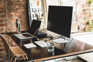 Image of a desk with a laptop and monitor