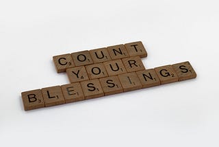 Scrabble pieces spelling out “COUNT YOUR BLESSINGS”.
