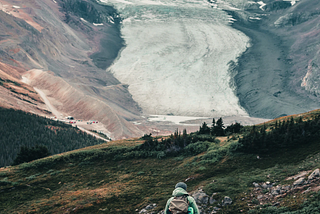 Someone looking up at a glacier.
