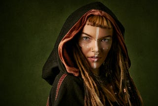 Beautiful red-headed medieval woman in a cape and hood