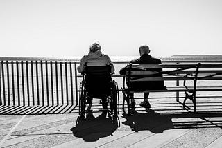 Photo of an old couple sitting together by the sea via Alt text on Medium