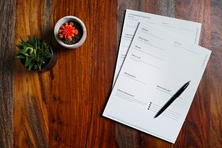 paperwork sitting on a desk with a pen on top of it