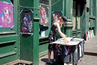 Woman selling art in New York street.