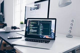 Minimal workspace with laptop displaying code.