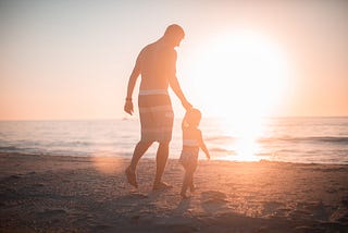 Father and daughter at the beach at sunset