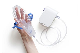 A hand holding an oxygen mask.