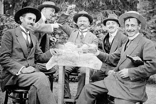 An old photo showing a group of having a picnic and enjoying themselves.