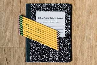 A composition book with pencils