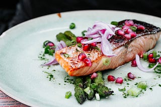 freshly made salmon with some pomegranate, onions, and greens.