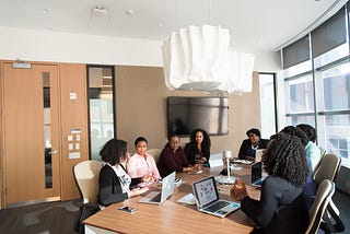 A group of women sitting in a meeting room having a discussion