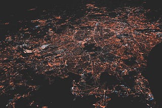 nighttime aerial photo of a city, streetlights and roads visible.