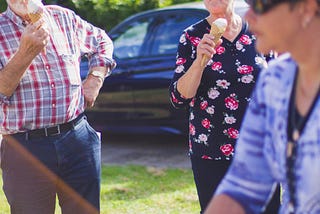 Two older people enjoying an ice cream.