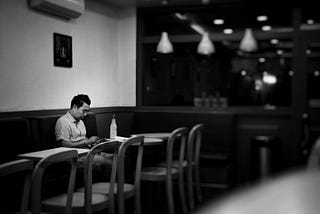 Man sitting by himself in a coffee shop.