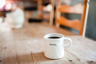 a coffee mug with the word BEGIN written on the front.