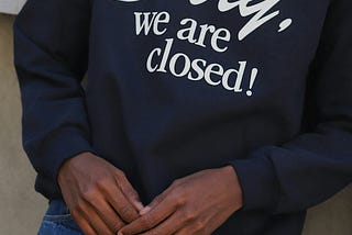 A picture of a T-shirt worn by someone and it has the writings “sorry we are closed,” used to signify someone who has chosen to limit unwanted access.
