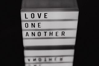 A digital sign bearing the words “Love one another”.