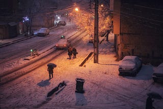 People walking in the snow at night