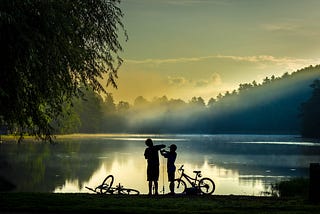 Taking a break. Two boys with bicycles on the lake.