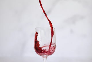 A glass of wine artistically poured from a bottle