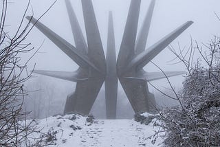 A dog runs towards a huge metal war looking object in a freezing location possibly in Russia.