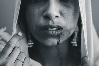 A black and white image of an Indian women who has really faced the struggle and is hurt badly and is bleeding because of the atrocities of the society.