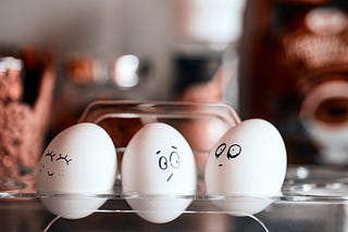 Photo of 3 eggs with silly faces drawn on them, one happy, one confused, one tired, to illustrate emotions