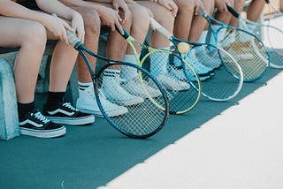 row of tennis players and rackets