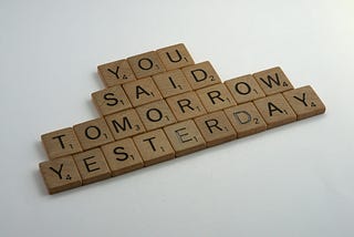 an image of wooden squares with letters that spell the phrase, “YOU SAID TOMORROW YESTERDAY”