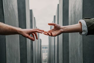 A photo of two hands reaching out to each other.