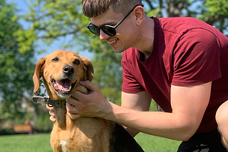 Dom in a park playing with a dog.