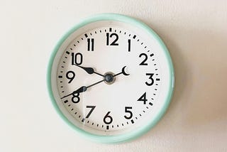 A clock on the wall with a light green rim.