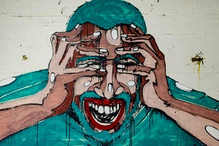 A painted picture of a man with his hands on his face, his mouth is open. His hair, beard and shirt are green, his skin is tanned or brown. It seems to depict extreme fear or anxiety.