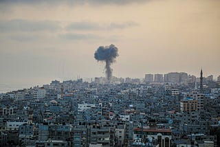 A cloud from an explosion rises over an image of Gaza’s city scape.