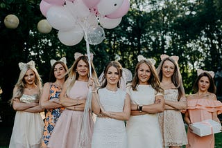 Seven girls at a birthday party. They are dressed similarly but not exactly alike.