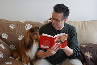 Man reading with dog