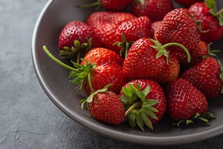 paln gray background with a bowl of strawberries