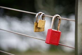 closed locks hanging from a fence