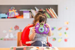 toddler holding up toy camera to the real camera