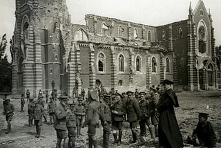 World War I soldiers gathered around the ruins of a heavily damaged church, highlighting the impacts of war on historical architecture.